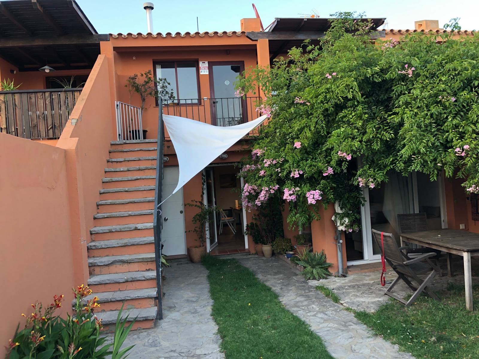 Vista amplia de la terraza de dos niveles del apartamento con jardín